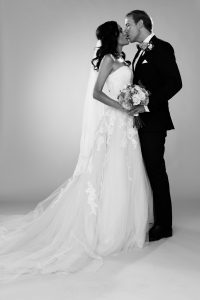 Studiobröllop, brudparet kysser varann i helkropp svartvitt