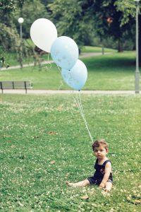 Bebis i parken med ballonger